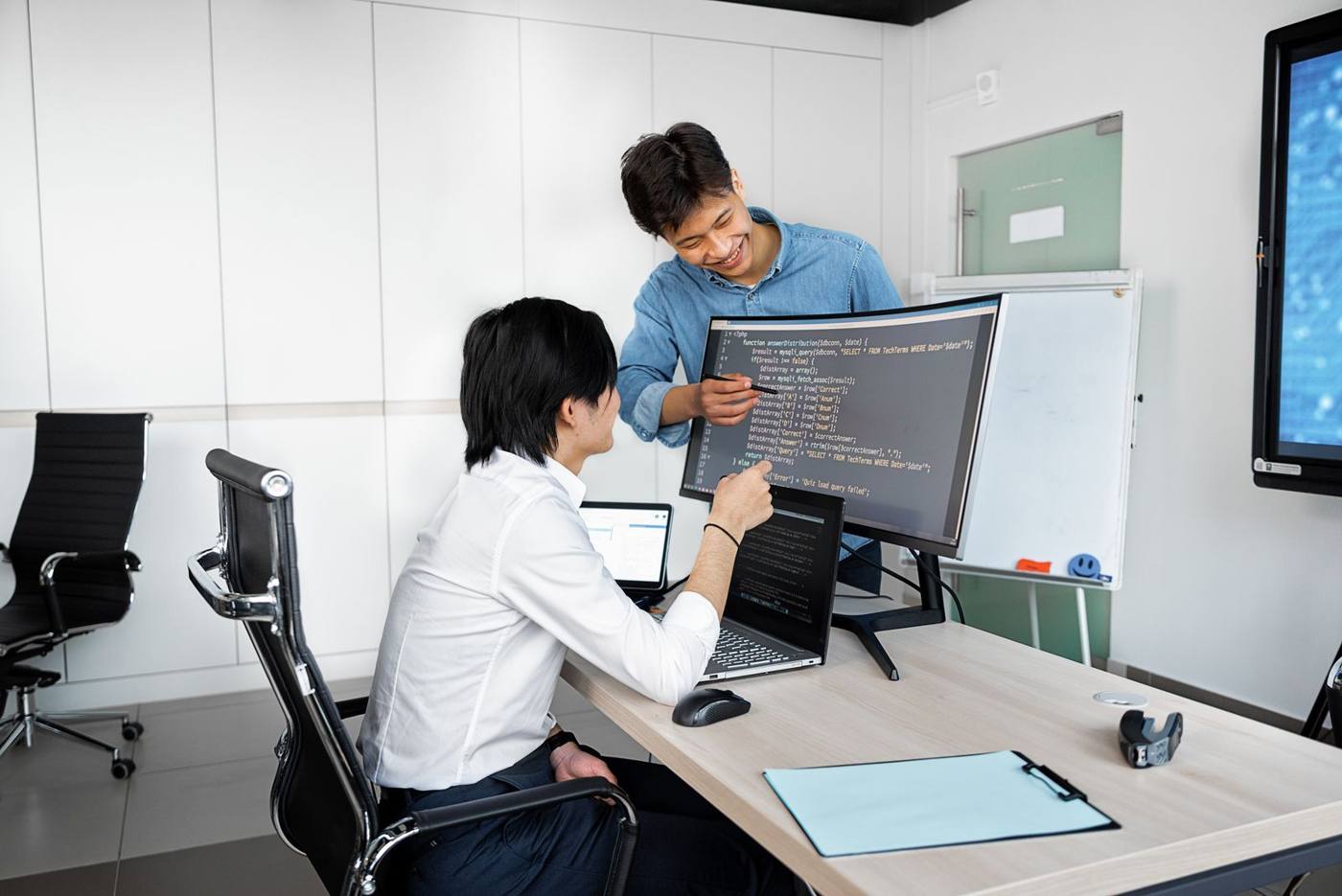 A team of developers reviewing code and software architecture at the office, laptops open