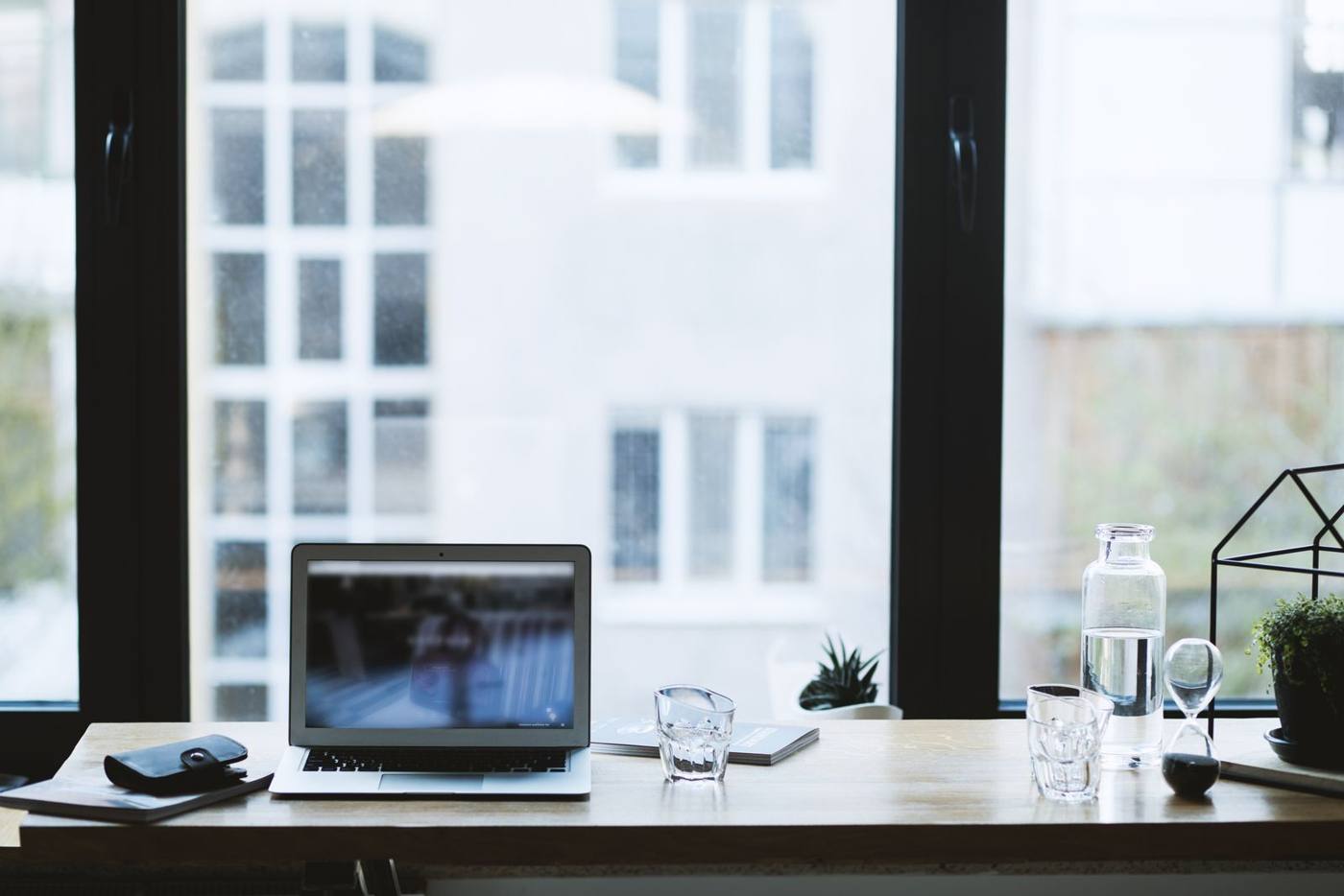 A small workspace with a desk, laptop and a plant, in natural light, in Bucharest.