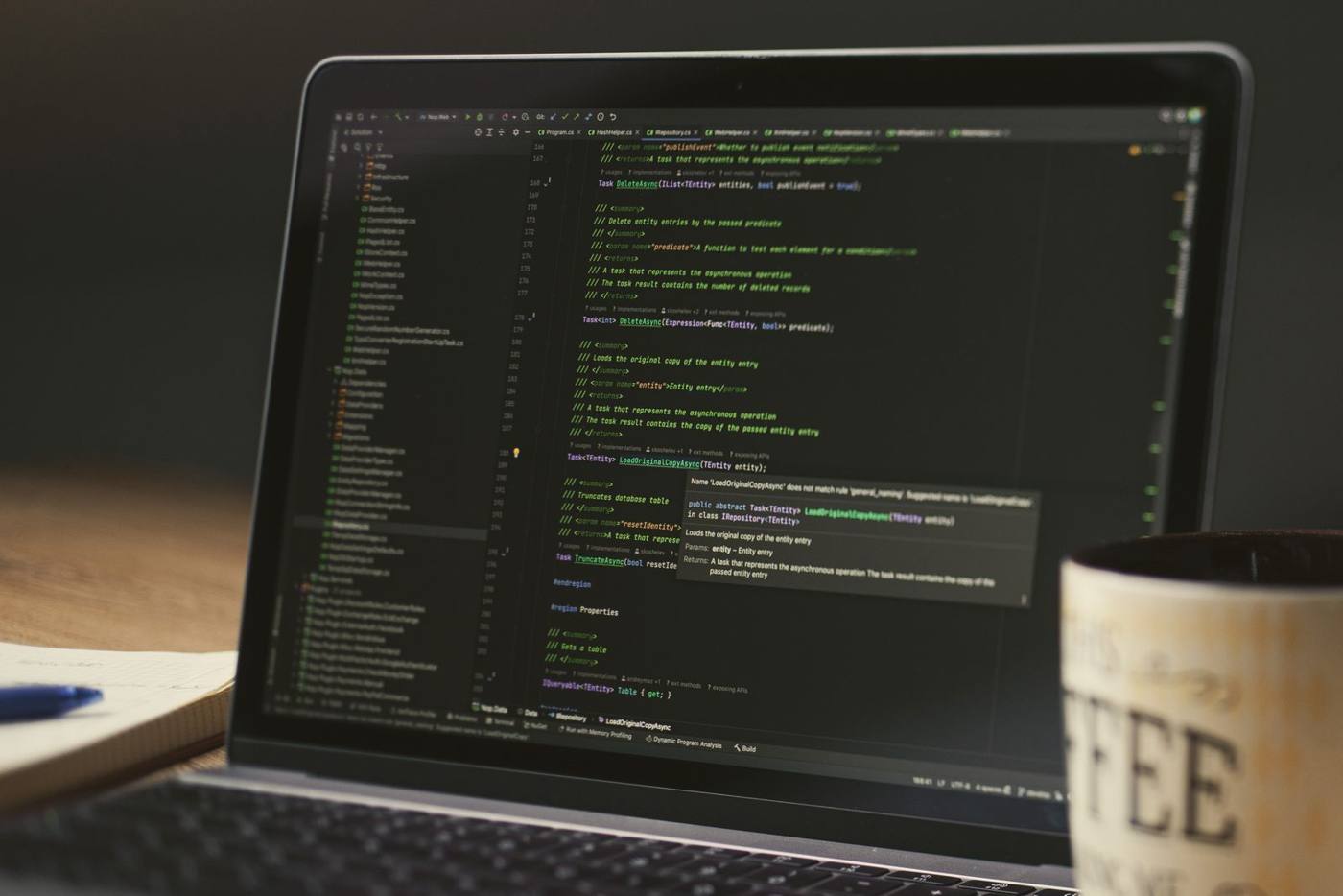 Laptop showing code next to a coffee mug on a desk, during a technical check of a website