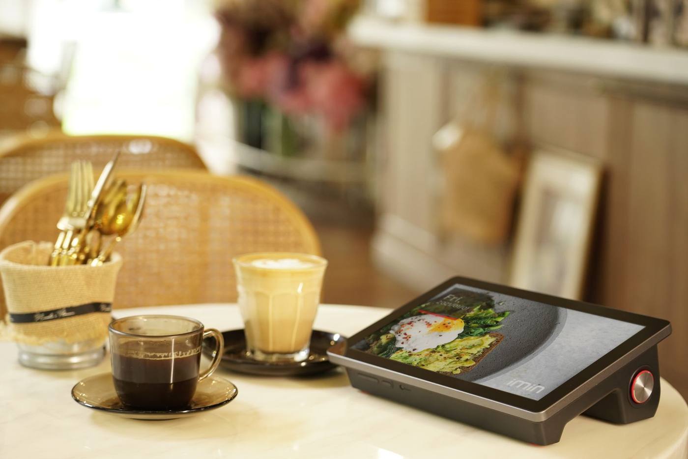 Waiter presenting a digital menu on a tablet at the customers' table