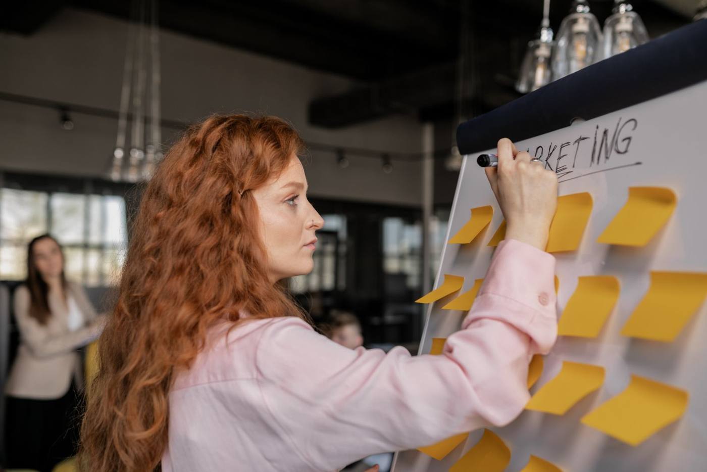 A marketing planning session, with sticky notes on a whiteboard, around a table.