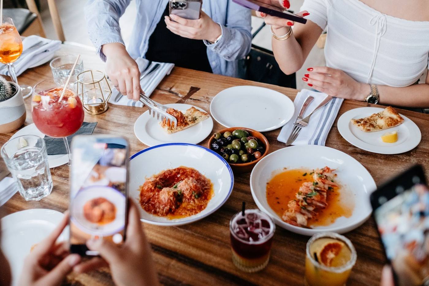 A customer scanning a QR code on a restaurant table with their phone, for the digital menu.
