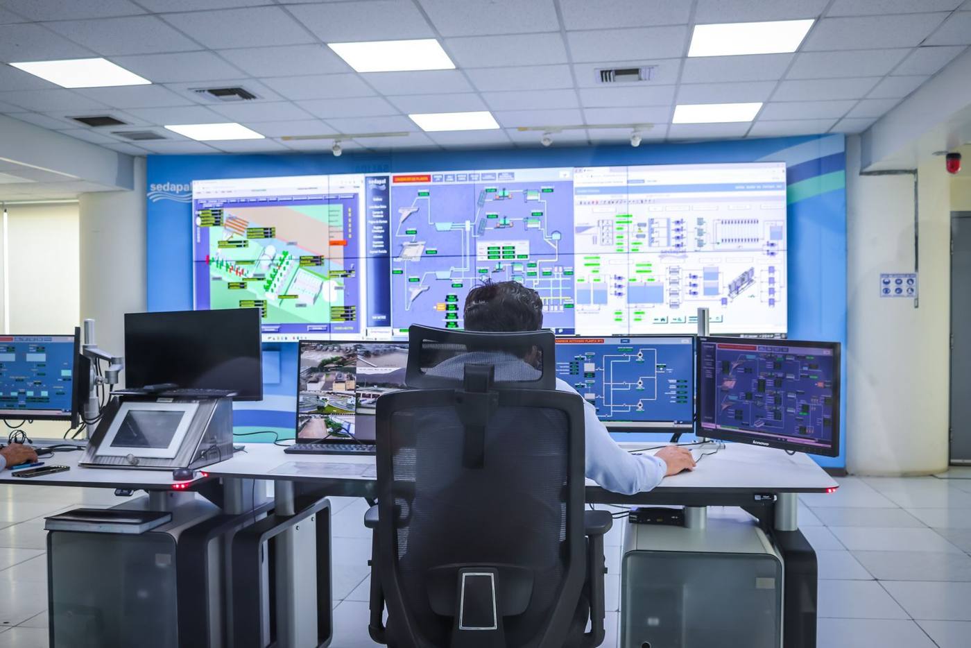 Employees at an industrial company analyzing an operational data dashboard together on screen.