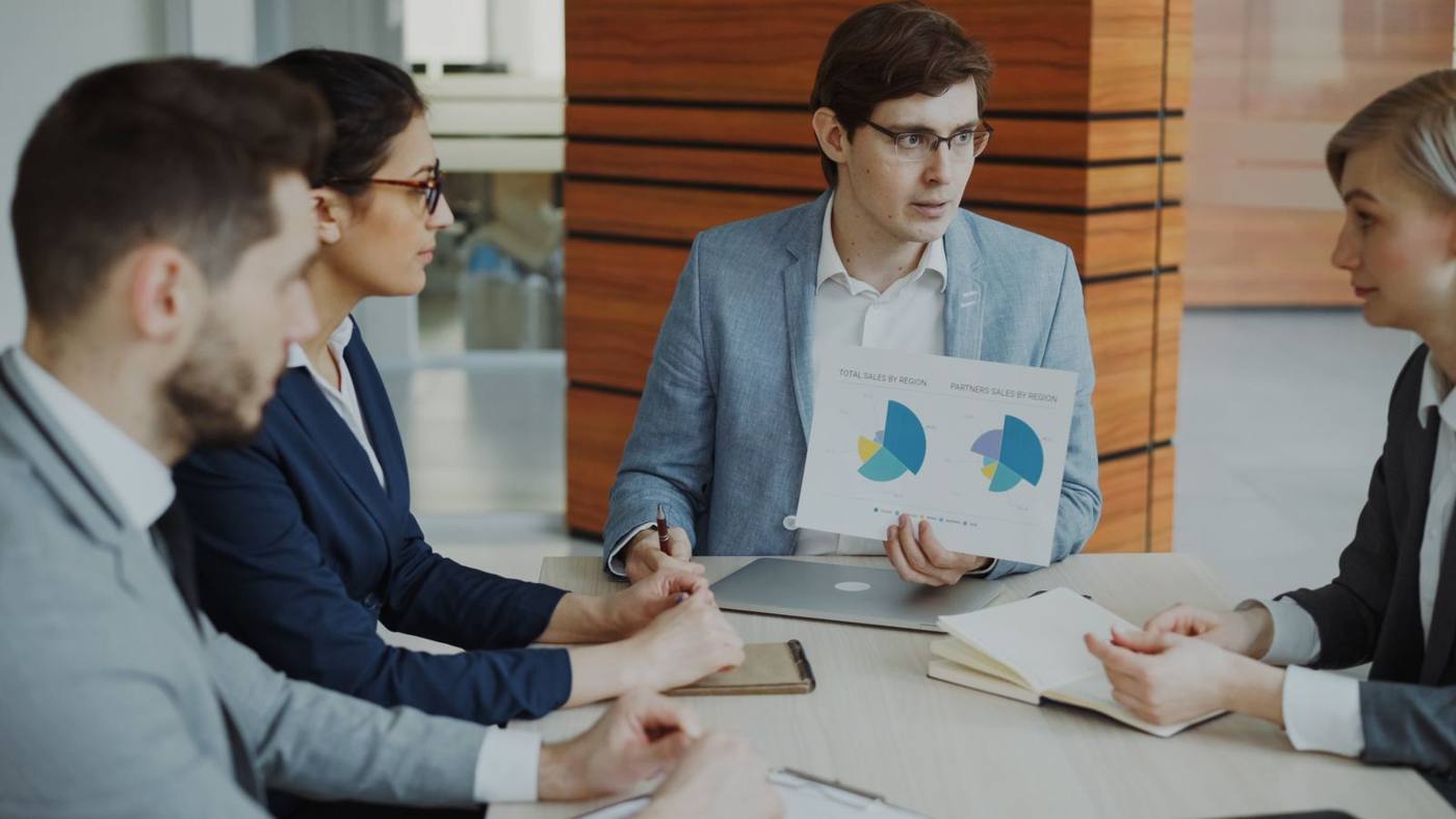 B2B sales team analysing a lead pipeline on a laptop, modern office