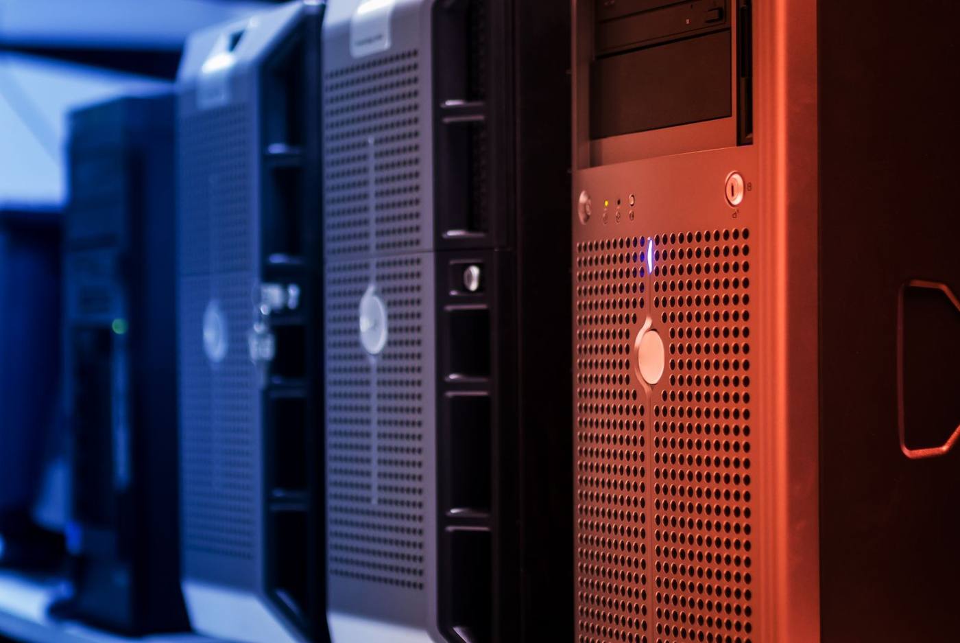Tower servers standing side by side, with their status lights on